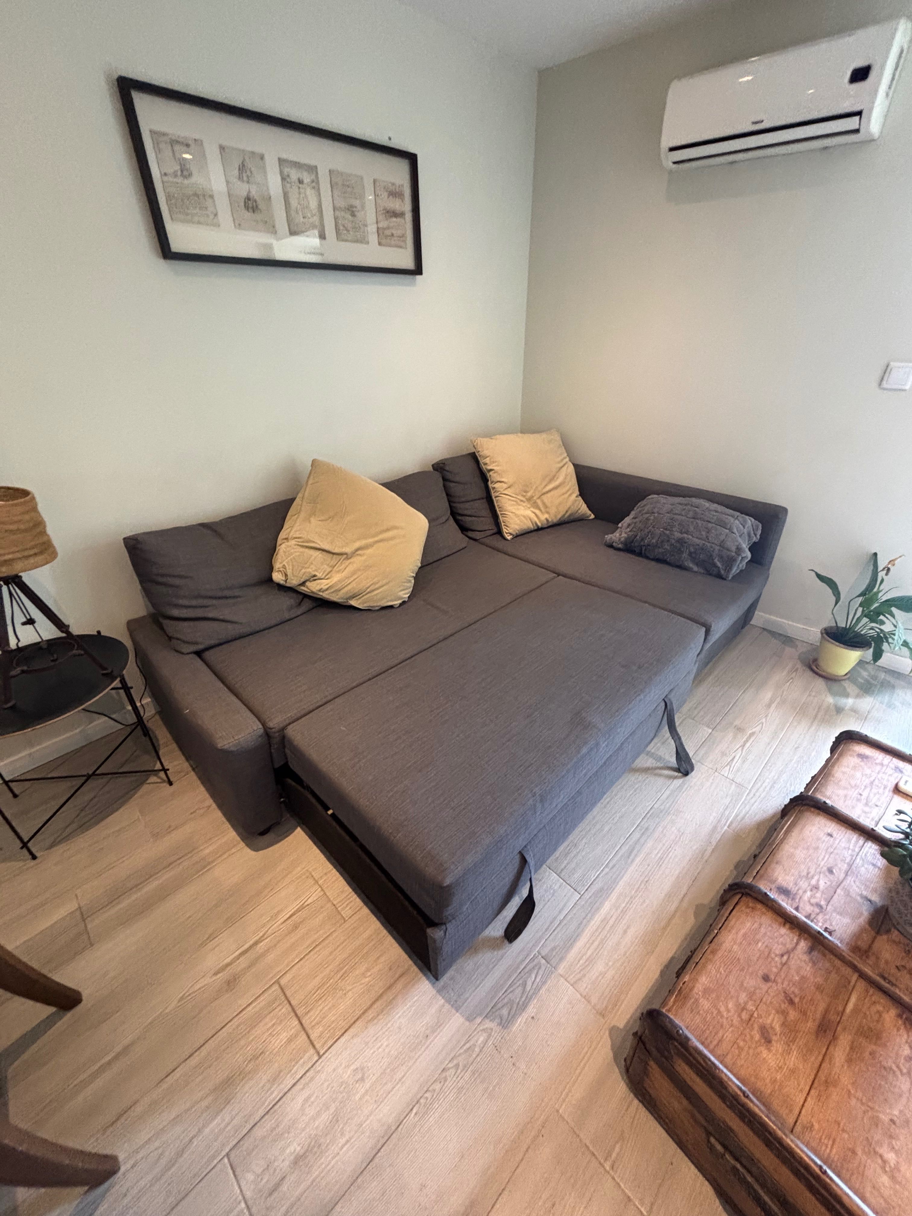 Sofá cama preto IKEA com chaise long e espaço de arrumação