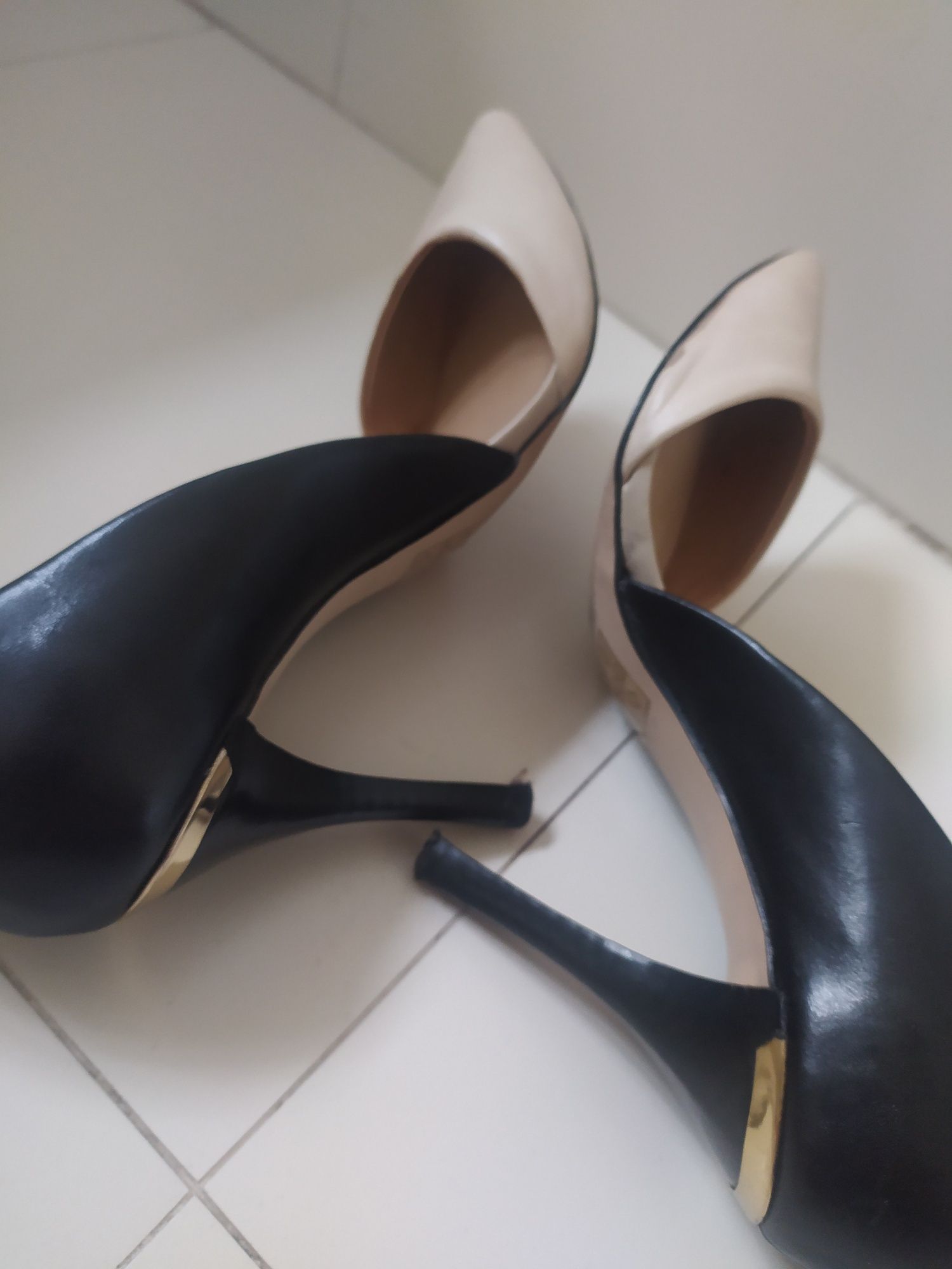 Sapatos cores beje e preto.