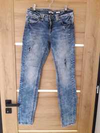 Spodnie jeans z przetarciami Reserved