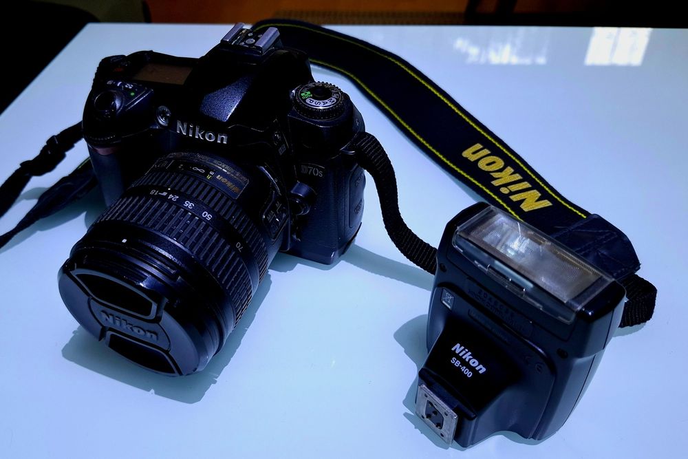 Aparat Nikon D70S z obiektywem i lampą
