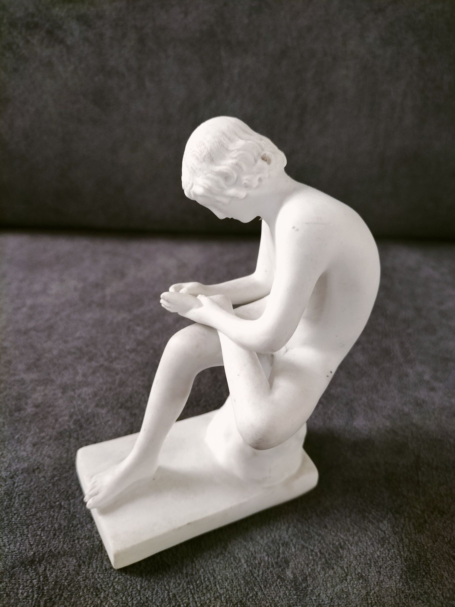 Porcelanowa figurka spinelio chłopiec z kolcem.