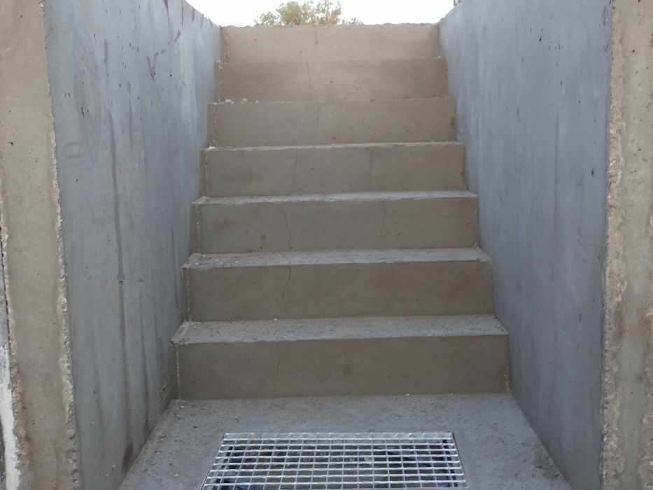 Schody betonowe do piwnicy betonowej kotłowni ze spocznikiem i kratką