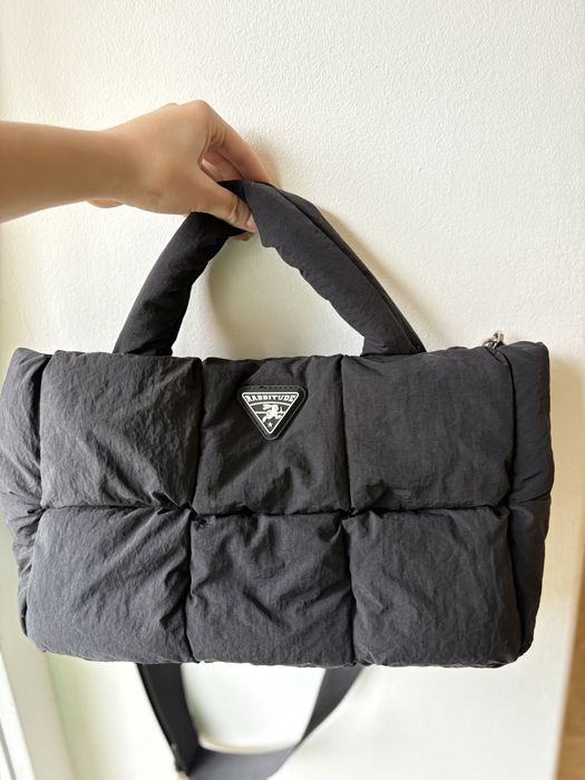 Це чорна стьобана сумка-тоут від Rrabbitude.