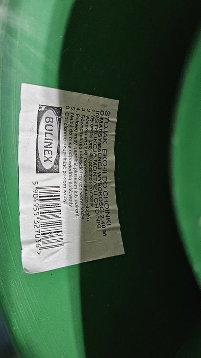 Zielony plastikowy stojak na choinkę z tacą na wodę .