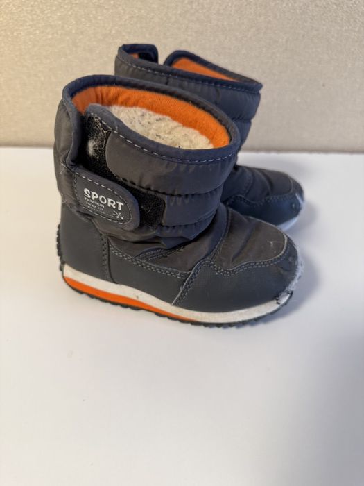 Дитячі зимові сапожки біля дому