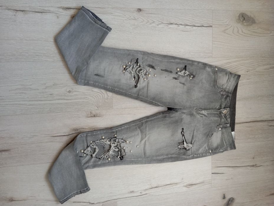 Szare jeansy bogato zdobione z dziurami modne