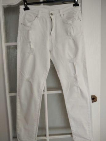 Białe spodnie z modnymi przetarciami