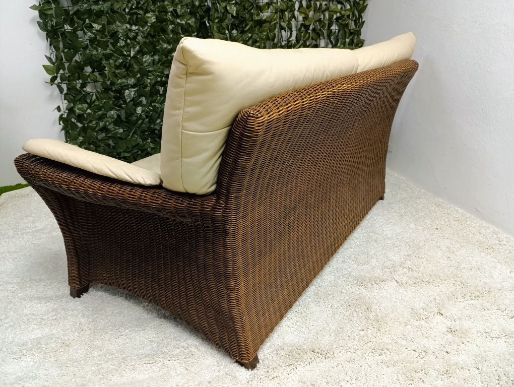 Piekna sofa rattanowa z poduchami ze skóry naturalnej.