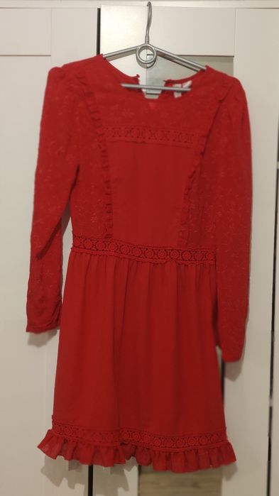 Czerwona piękna sukienka z koronkowymi ozdobami i haftami