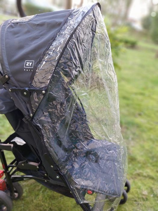 Carrinho de bebê com capa de chuva da marca Zippy.