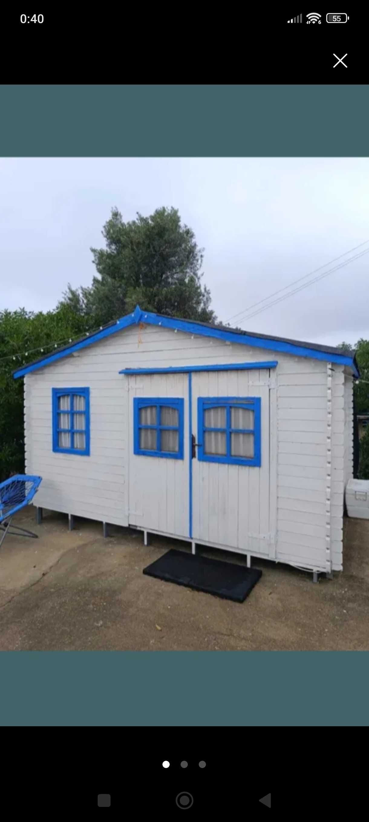 Um container/contentor e uma casinha/casota de madeira na venda