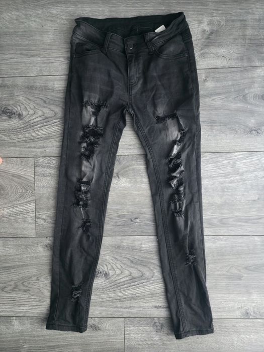 Dopasowane spodnie jeansowe skinny z przetarciami dziurami na nogawkac