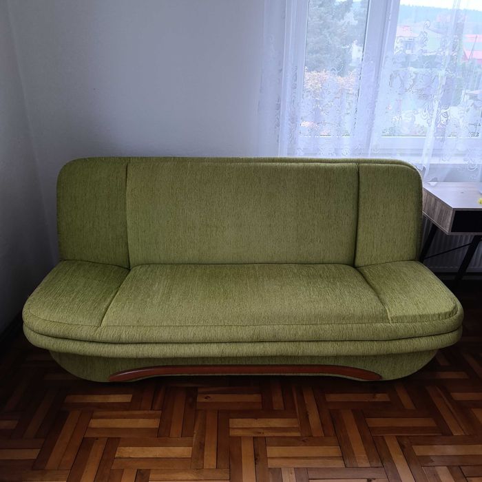 Seledynow-zielona kanapa rozkładana z pojemnikiem na pościel