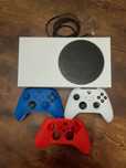 Konsola Xbox series s. Z dwoma kontrolerami i jedną nakładką.