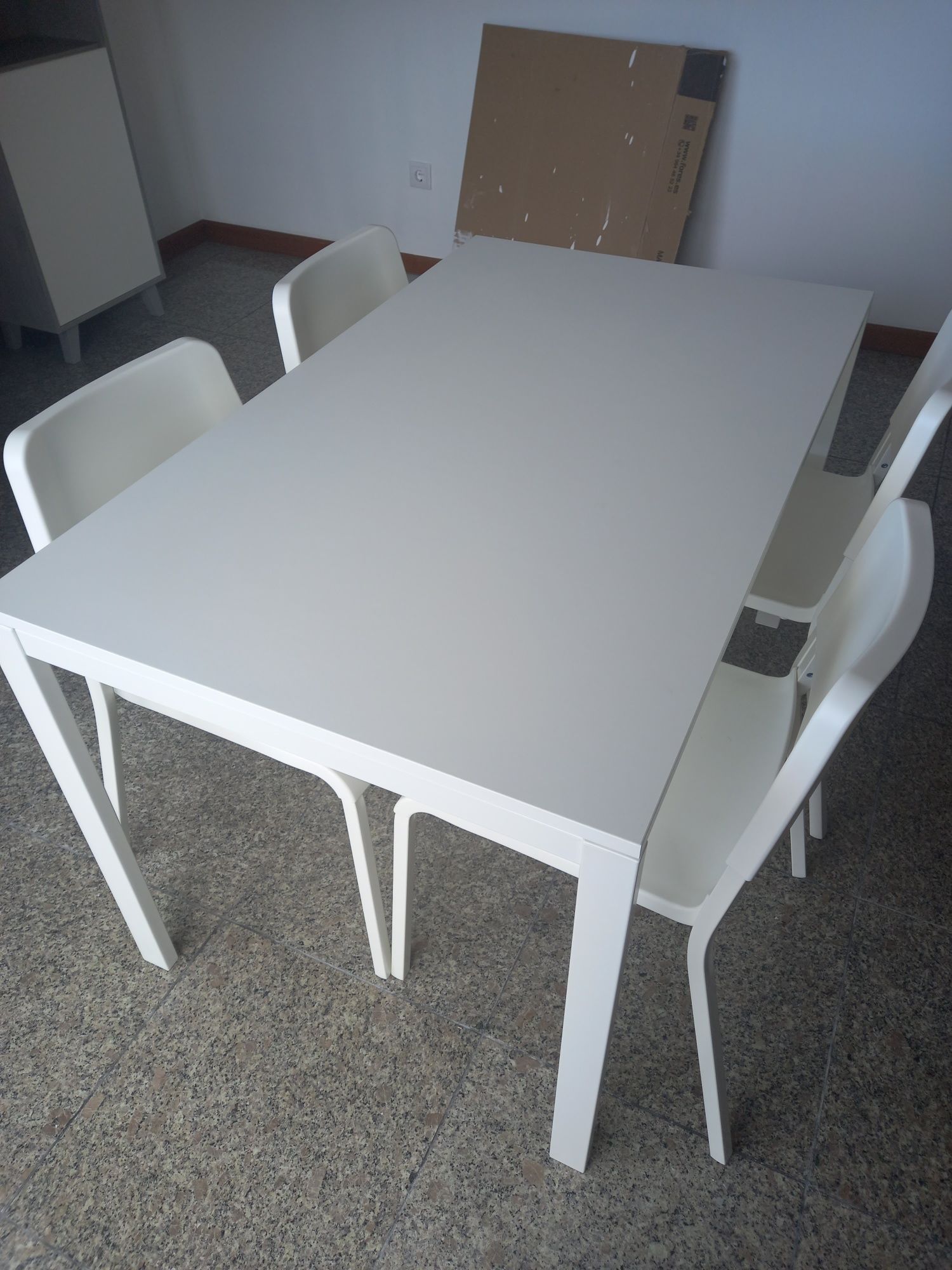 Mesa com quatro cadeiras brancas