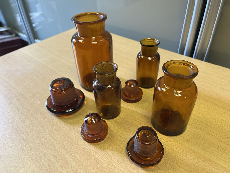 Wiekowe brązowe butelki szklane z szeroką szyjką korkiem