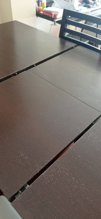 Mesa de madeira castanho escuro com seis cadeiras de pele