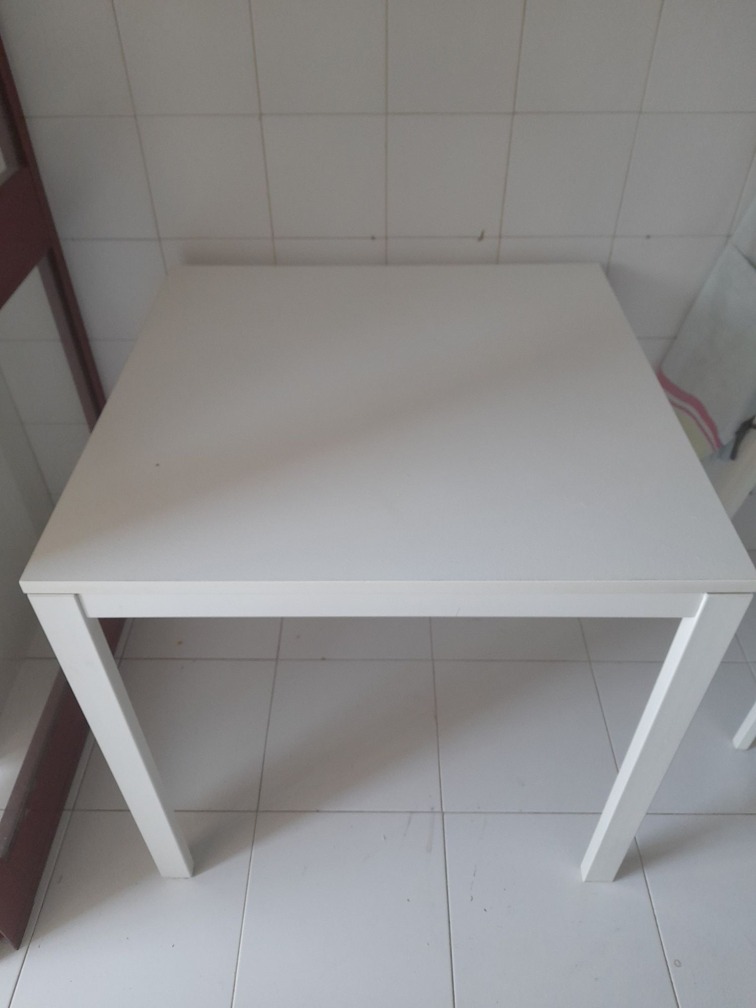 Mesa Ikea com uma pequena marca de uso no tampo.