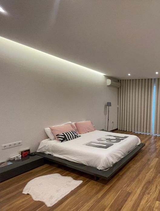 Cama com mesas de cabeceira e estrado