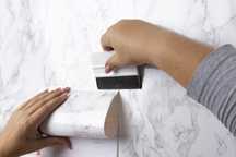 Aplicação de papel de parede e adesivo.