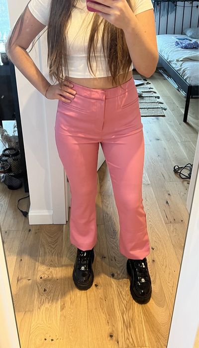 Różowe spodnie przed kostkę z rozszerzanymi nogawkami