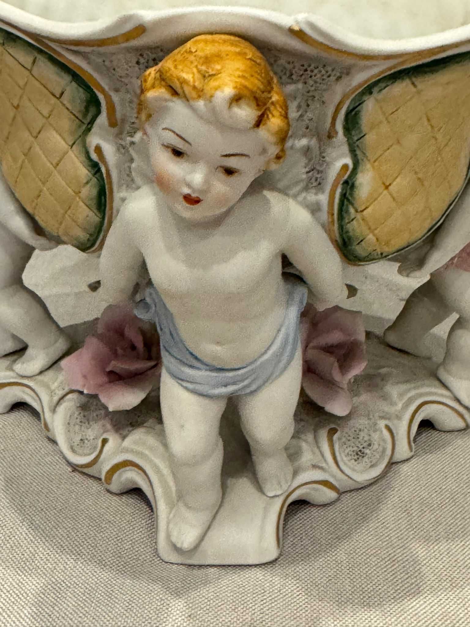 Misa (żardiniera) trzymana przez Putto, porcelana ręcznie malowana.
