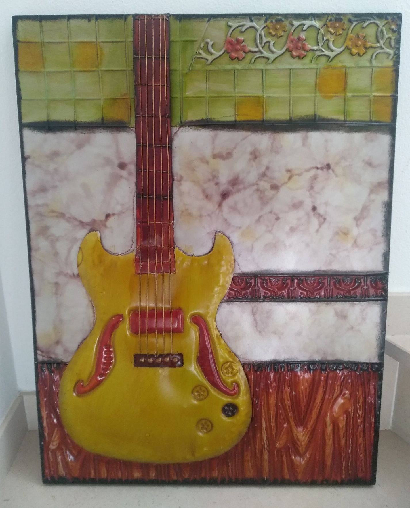 Quadro metálico com uma guitarra