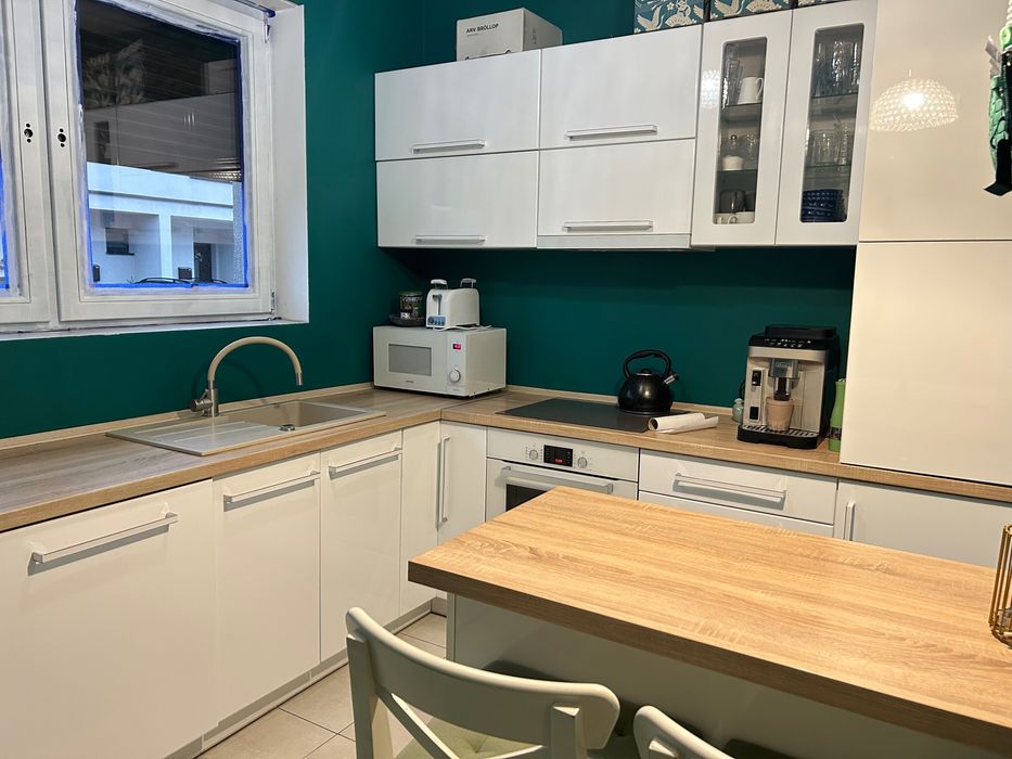 Kuchnia z wyspą kuchenną i krzesłami