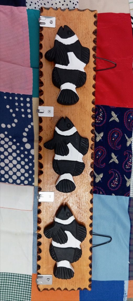 Placas decorativas em madeira com pequenos cabides.