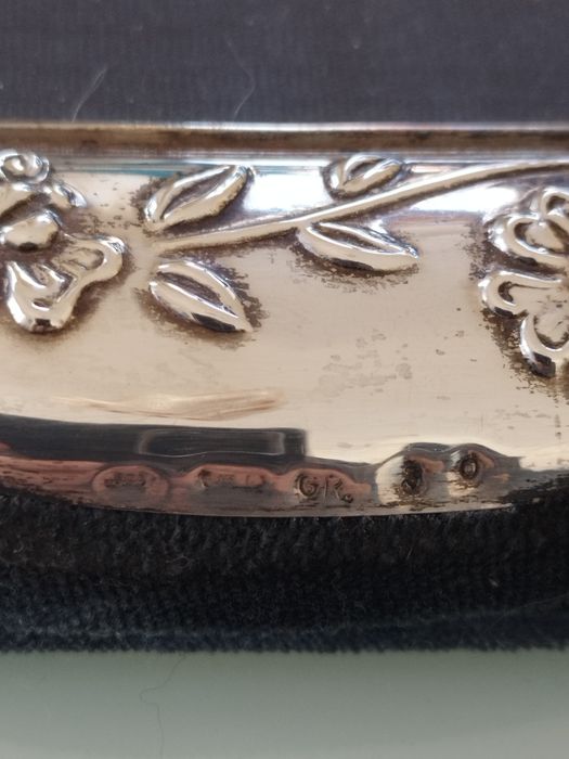 Moldura delicada com detalhes florais em relevo.

- Material: Prata
-