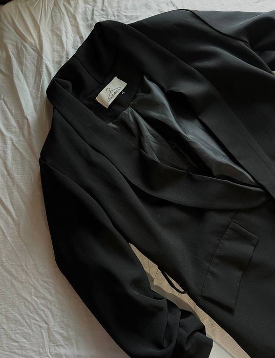 Елегантний подовжений чорний піджак.