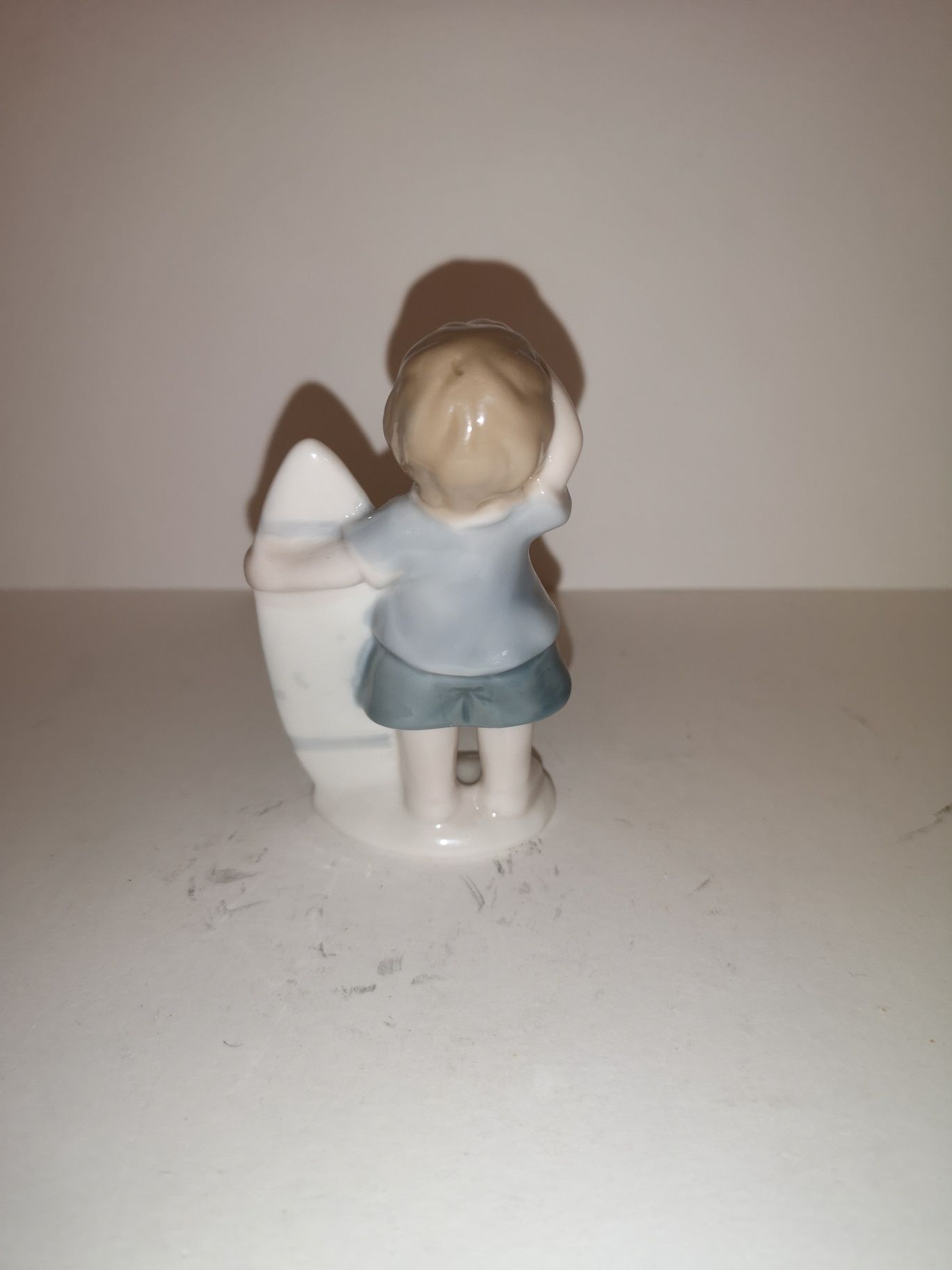 Porcelanowa figurka chłopca z deską serfingową