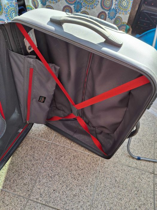 Mala de viagem cinzenta rígida com muito boa capacidade .