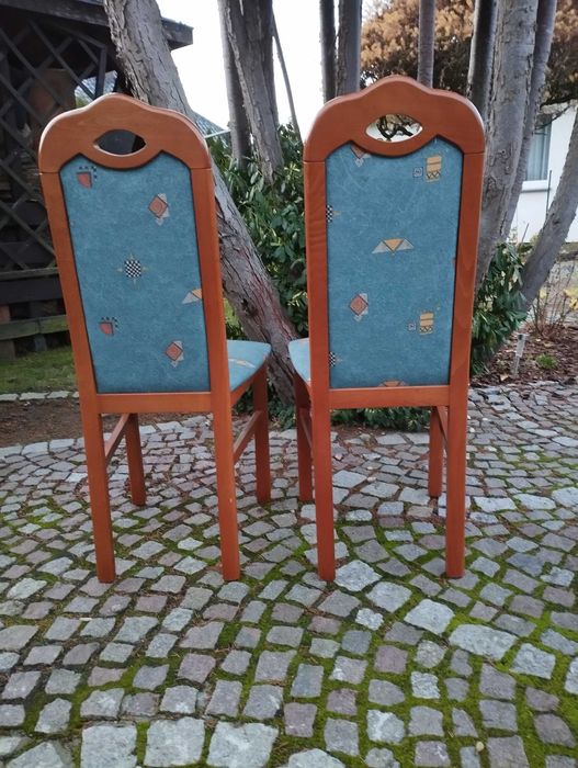 Owalny, rozkładany stół do salonu lub jadalni z krzesłami.