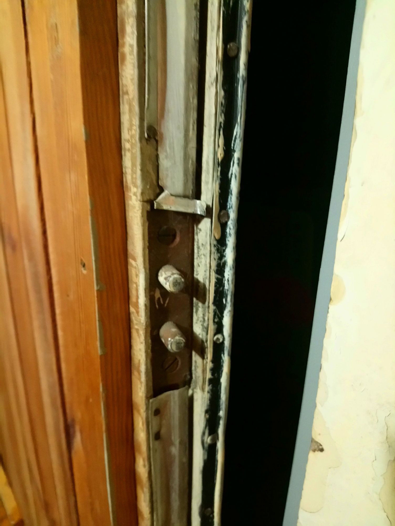 zdemontowane drzwi do mieszkania obite listewkami i wygłuszone
