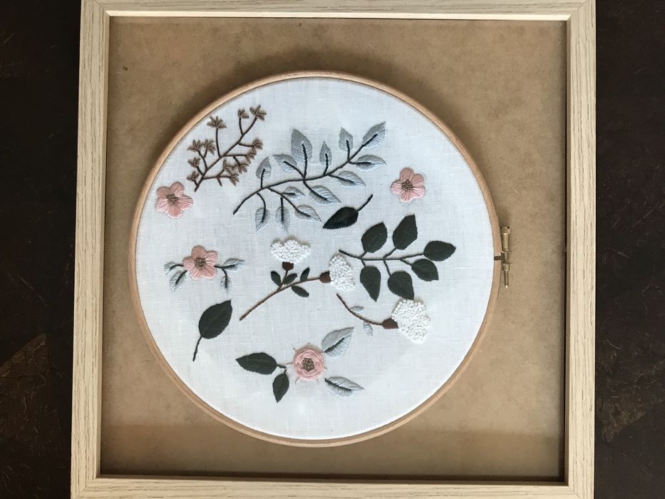 Quadros bordados à mão com motivos de flores.