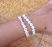 Duas pulseiras brancas com letras