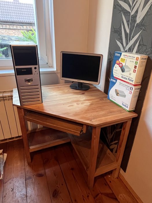 Biurko drewniane z komputerem i monitorem i routerem