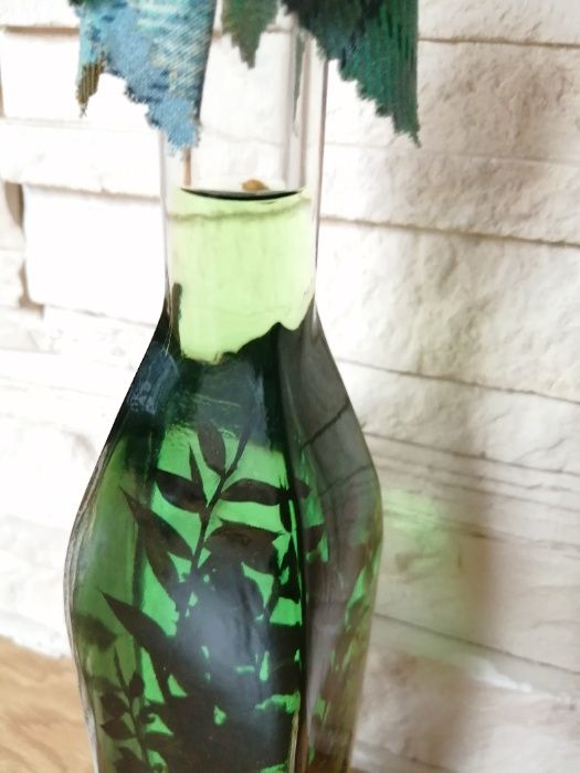 Butelka dekoracyjna z zielonym płynem i ziołami