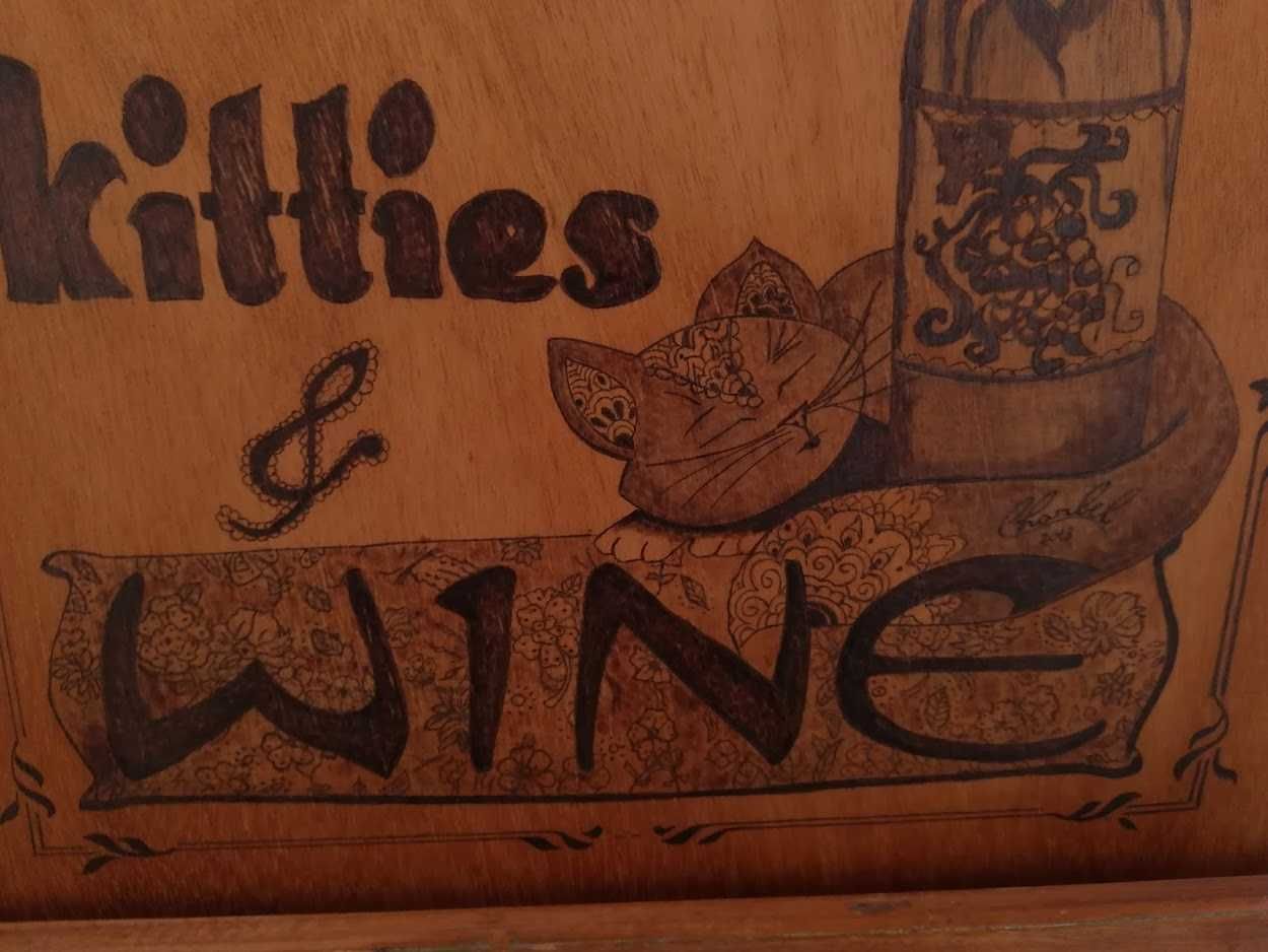 "wine & Kitties" gravado a "fogo".