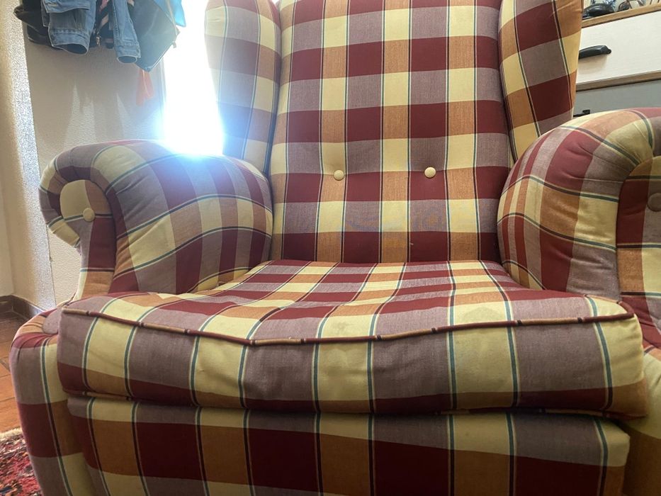 Poltrona vintage de orelhas com estampa xadrez.
