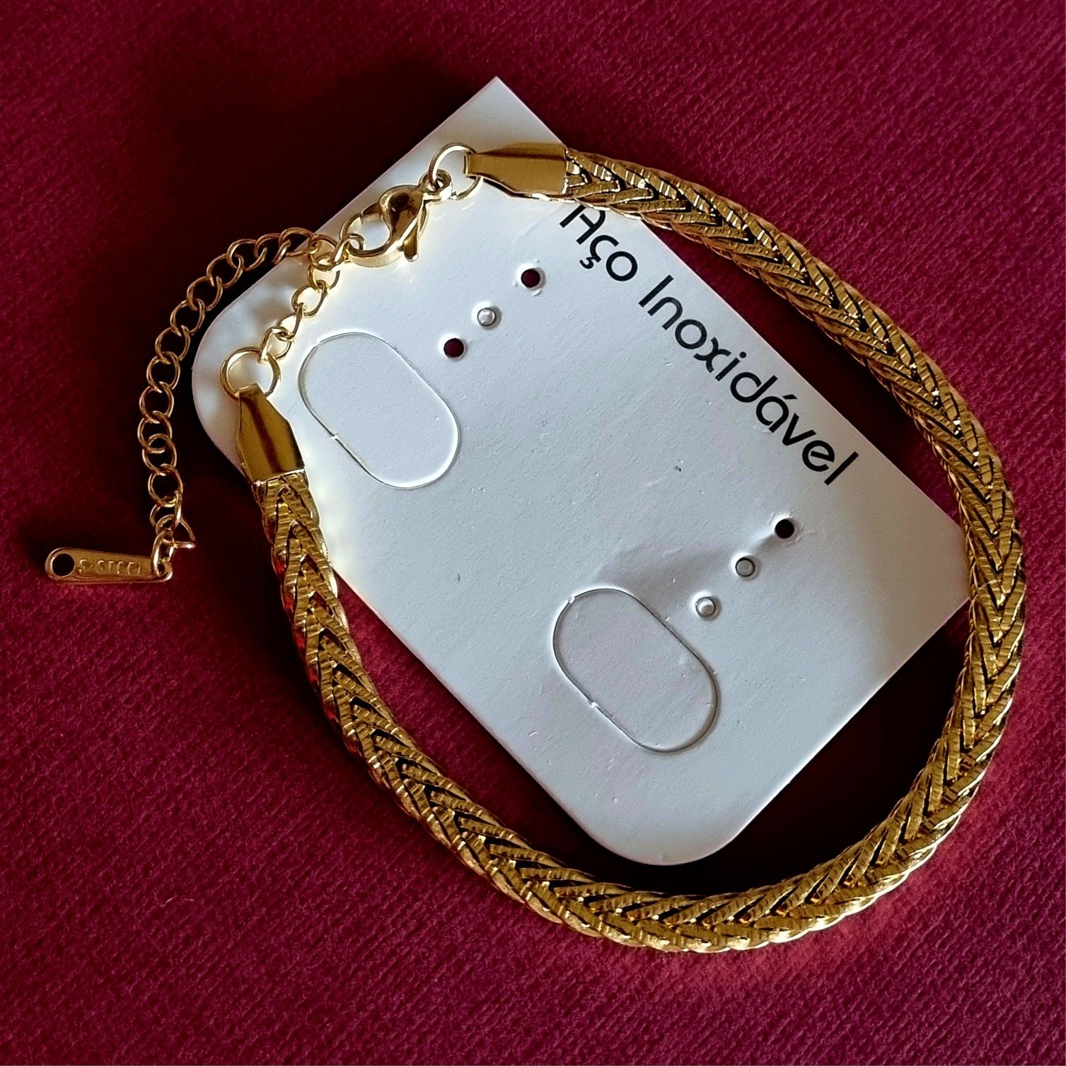 Pulseira dourada, em aço inoxidável. Tem extensor