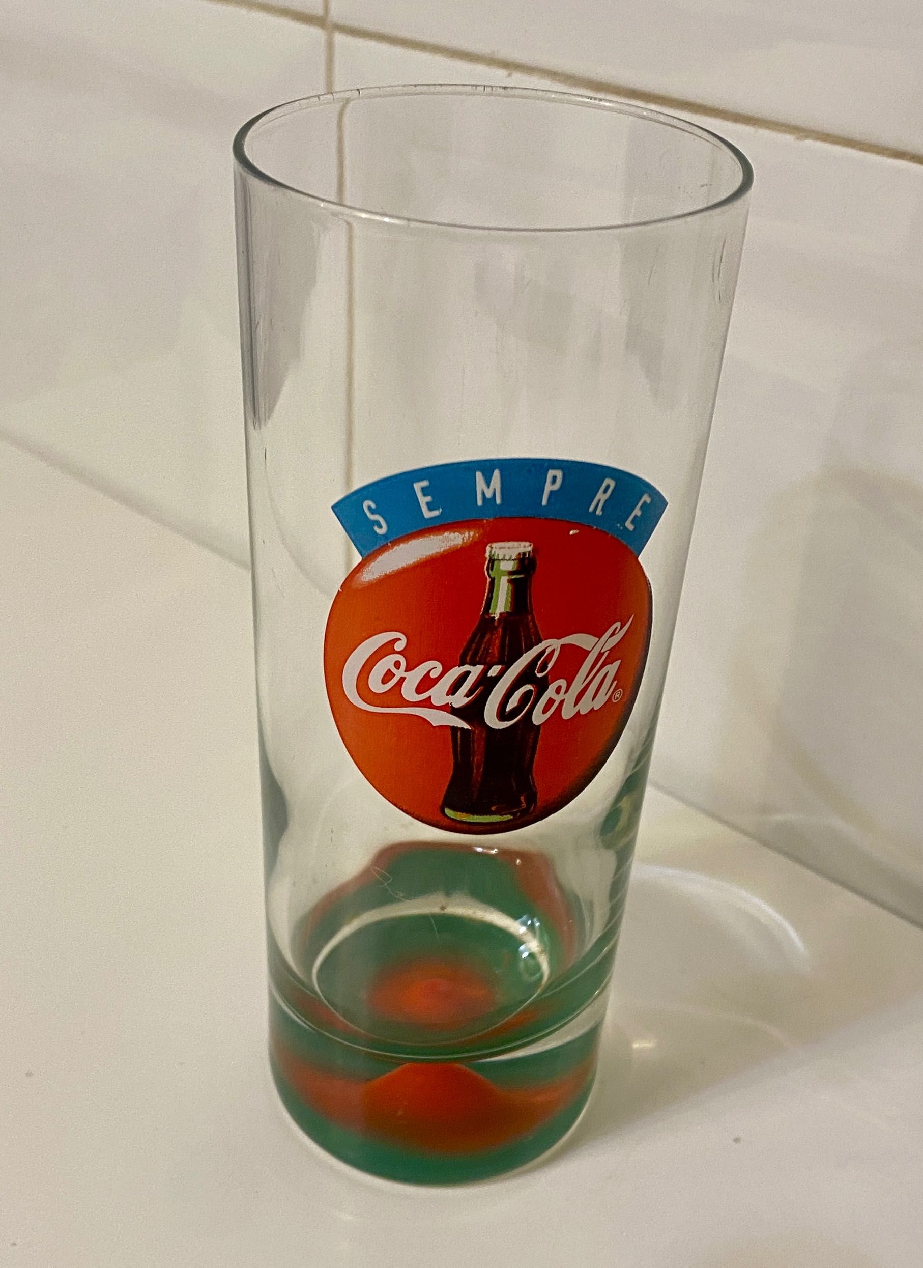 Copo antigo coca cola com relevo mama no fundo.
