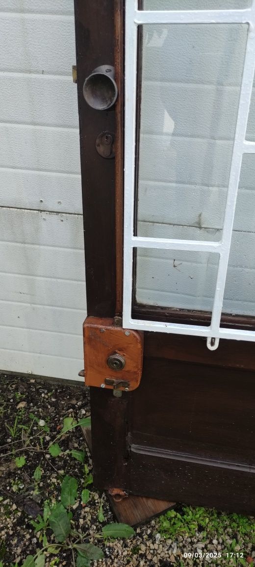 Porta larga em mogno com grade de segurança.