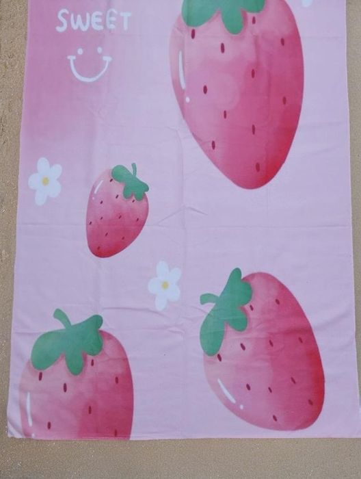 Toalha de praia com desenhos de morangos