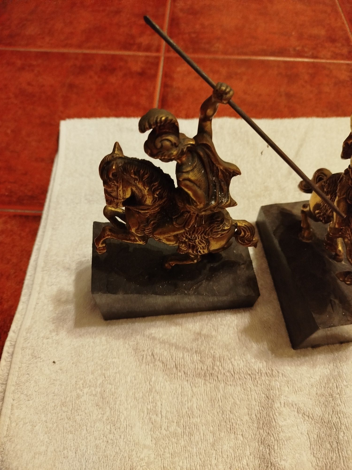 Duas esculturas antigas de um guerreiro em bronze e bases de mármore