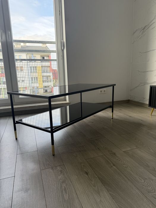 Czarna szklana ława ze złotymi dodatkami