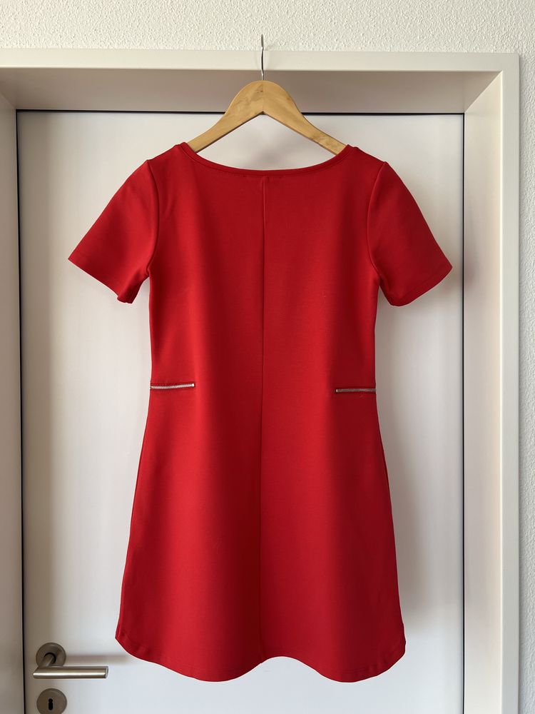 Czerwona sukienka z ozdobnymi zamkami