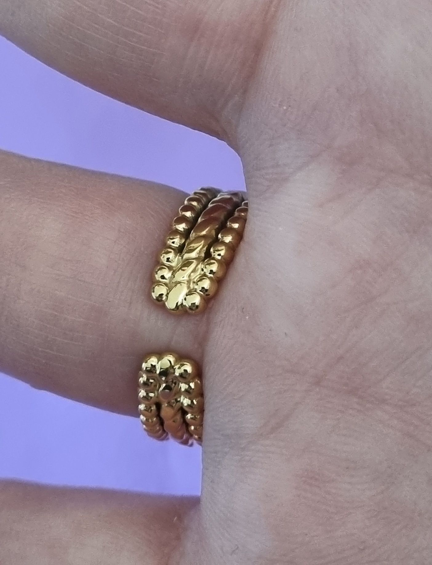 Anel dourado, em aço, com meia bola riscada. Ajustável