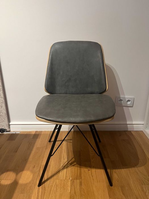 Szare krzesło z drewnianymi elementami i czarnymi metalowymi nogami